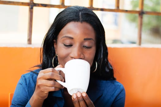 This young businesswoman holds a cup now in hand drinking coffee in the morning.