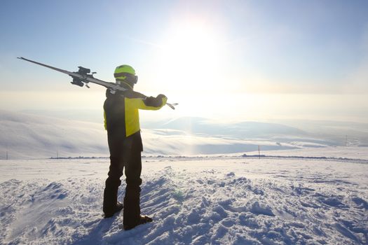 Skier on ski slope with mountains in background