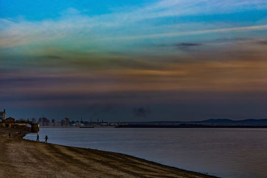 Sunset on the embankment of the Amur river in Khabarovsk. The sun set over the horizon. The embankment is lit by lanterns.