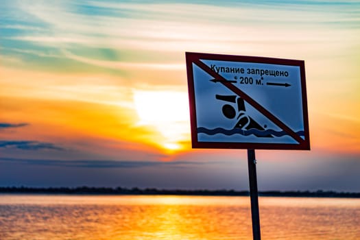 Sunset on the embankment of the Amur river in Khabarovsk. The sun set over the horizon. The embankment is lit by lanterns.