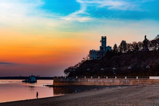 Sunset on the embankment of the Amur river in Khabarovsk. The sun set over the horizon. The embankment is lit by lanterns.