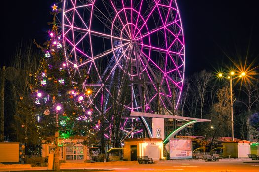 The largest artificial skating rink in the far East of Russia. At night. Many Christmas trees decorated with bright lights.