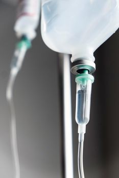 Close up of IV saline solution drip for patient in hospital