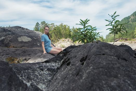 Woman resting at river in Altai Mountains territory