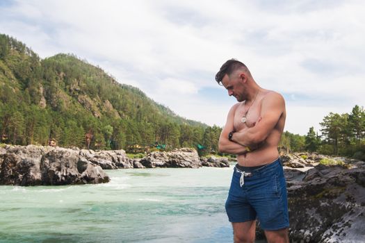 Man resting at river in Altai Mountains territory