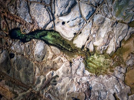 Cratered weathering and erosion on ocean rock shelf