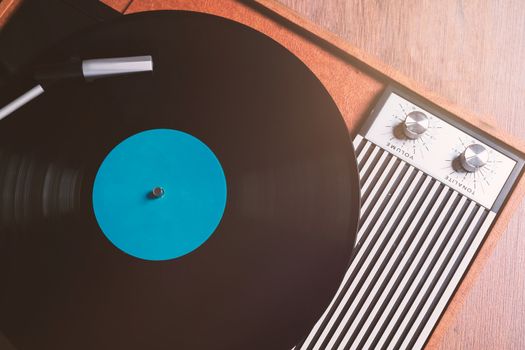 Vintage Gramophone with a vinyl record on wooden table, top view  close up,vintage style.