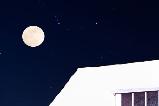 winter season at night, a rooftop covered in a thick layer of snow with stars and a full moon, christmas background