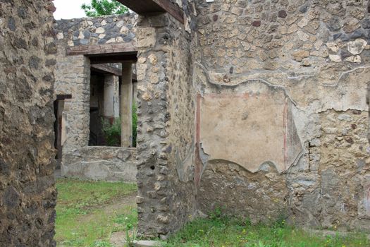 Meadow green grass under old ruined stone walls of Italian Roman Pompei