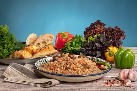 Asian traditional pilaw and vegetables on a wooden table