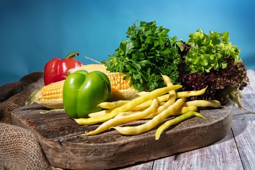 Maize, greenery and pepper on a wooden table