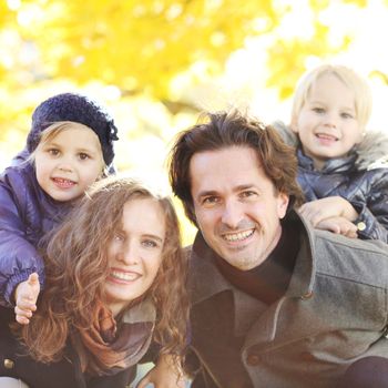 Parents and children having fun in yellow autumn park