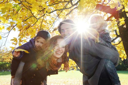 Parents and children having fun in yellow autumn park