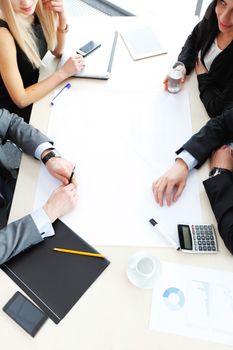 Business people sitting at table with electronic devices on meeting