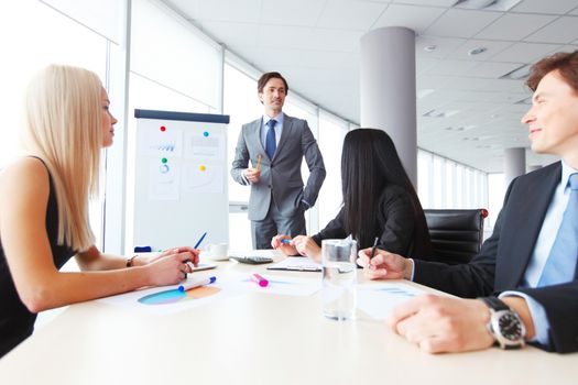 Workers at business meeting looking at presentation of financial reports in modern office