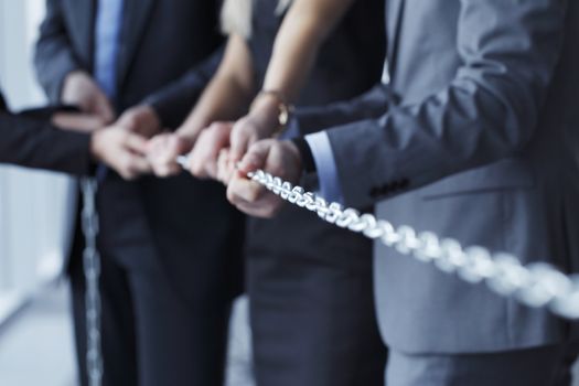 Businessmen pulling chain, teamwork togetherness concept