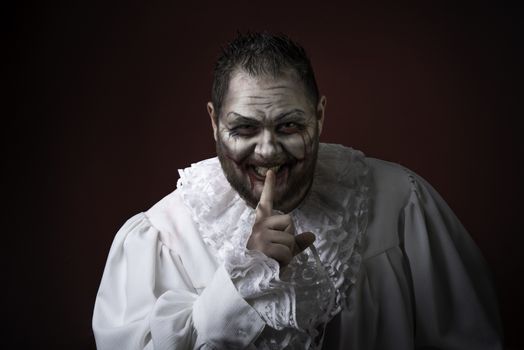 Portrait of a Scary Evil Clown.  Studio shot with horrible face art