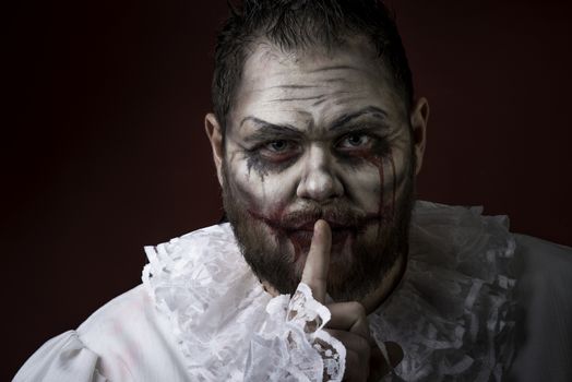 Portrait of a Scary Evil Clown.  Studio shot with horrible face art