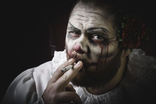 Portrait of a Scary Evil Clown.  Studio shot with horrible face art