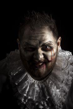 Portrait of a Scary Evil Clown.  Studio shot with horrible face art