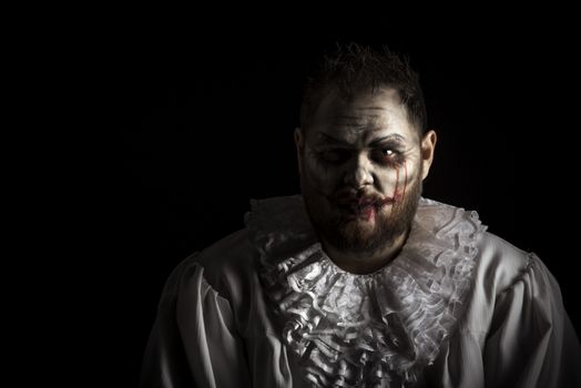 Portrait of a Scary Evil Clown.  Studio shot with horrible face art