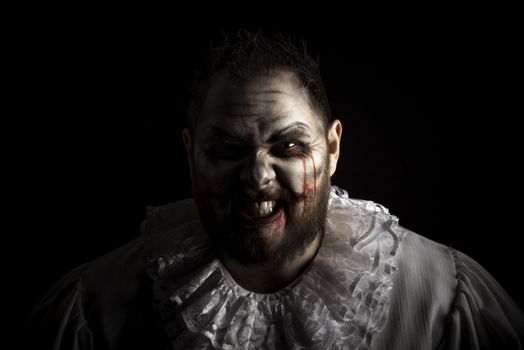 Portrait of a Scary Evil Clown.  Studio shot with horrible face art