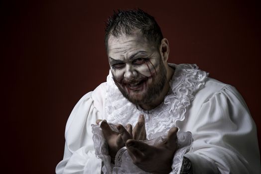Portrait of a Scary Evil Clown.  Studio shot with horrible face art