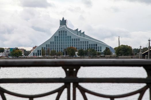 Latvian National Library. Cityscape from November 11 embankment with Latvian National Library in Riga. November 11 embankment bridge railings and National Library. National Library in center of Riga.