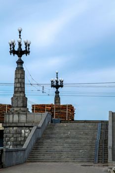 View of the Akmens bridge from the 11th November Embankment. Stairs to the stone bridge and lanterns in Riga, Latvia. Stairs to bridge on background of blue sky in Latvia. Stone bridge in Riga city.