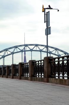 View of the Railway bridge from the 11th November Embankment in Riga, Latvia. Behind the railway bridge can see the television tower. Bridge crossing train. 