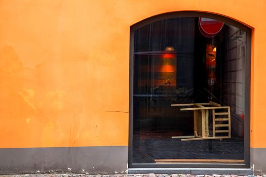 Fragment of orange wall with shop window in Old Riga, Latvia.