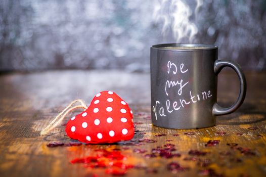Valentine's day concept with black cup, chalk inscription on a mug and a red heart.