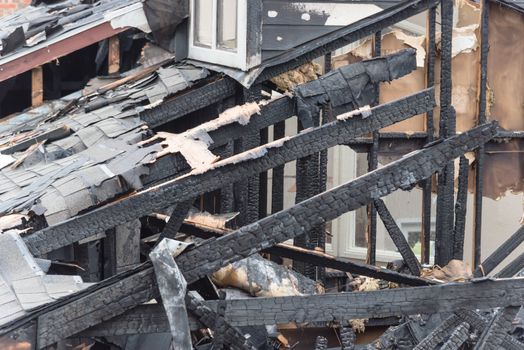 Close-up the roof of damaged apartment after burned by fire in Texas, America. Smoke and dust in burn scene of arson investigation course. Insurance theme of fire devastated