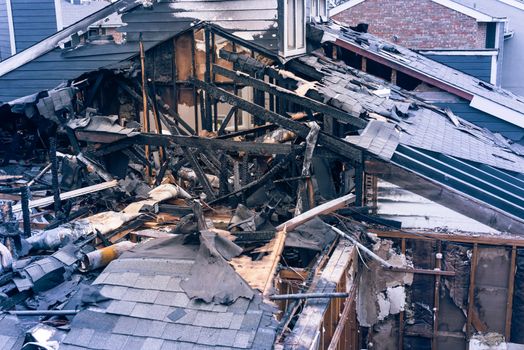 Close-up the roof of damaged apartment after burned by fire in Texas, America. Smoke and dust in burn scene of arson investigation course. Insurance theme of fire devastated