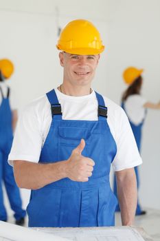 Workman gives thumbs up in front of two painters