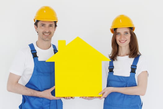 Construction workers showing house model symbol and friendly smiling