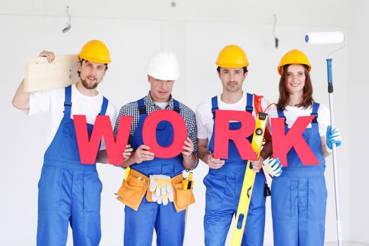Group of workmen with word WORK and tools indoors