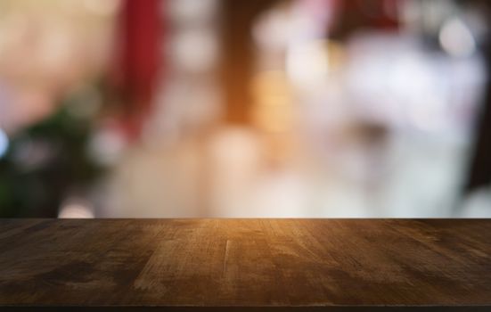 Empty dark wooden table in front of abstract blurred bokeh background of restaurant . can be used for display or montage your products.Mock up for space