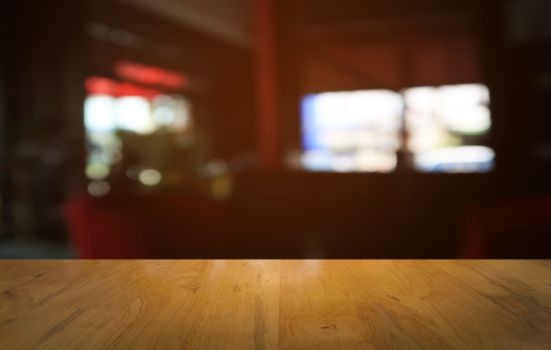 Empty dark wooden table in front of abstract blurred bokeh background of restaurant . can be used for display or montage your products.Mock up for space