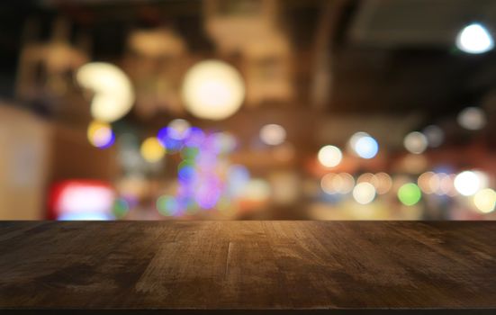 Empty dark wooden table in front of abstract blurred bokeh background of restaurant . can be used for display or montage your products.Mock up for space