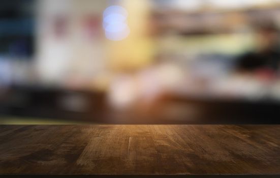 Empty dark wooden table in front of abstract blurred bokeh background of restaurant . can be used for display or montage your products.Mock up for space