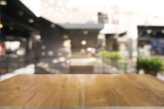 Empty dark wooden table in front of abstract blurred background of cafe and coffee shop interior. can be used for display or montage your products