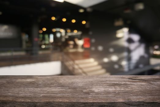 Empty dark wooden table in front of abstract blurred background of cafe and coffee shop interior. can be used for display or montage your products