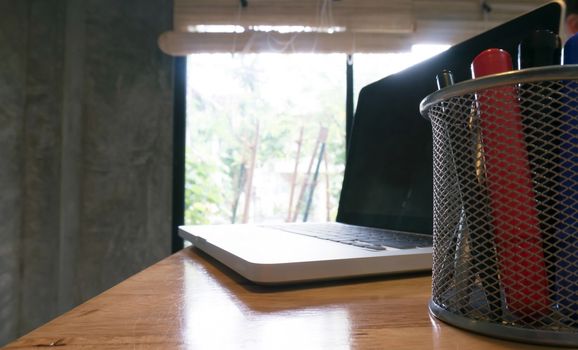 Laptop stands on a wooden table 