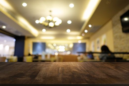 Empty dark wooden table in front of abstract blurred background of coffee shop . can be used for display or montage your products.Mock up for display of product