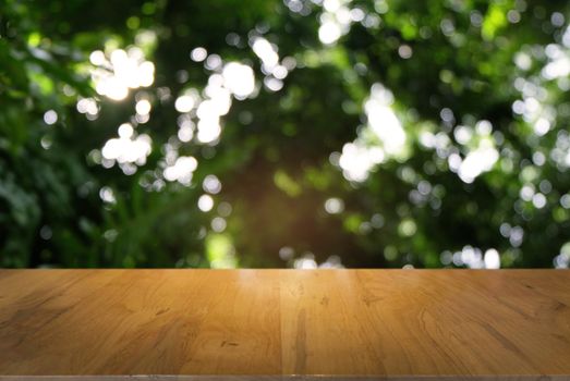 Image of dark wooden table in front of abstract blurred background of outdoor garden lights. can be used for display or montage your products.Mock up for display of product.