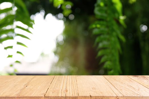 Image of dark wooden table in front of abstract blurred background of outdoor garden lights. can be used for display or montage your products.Mock up for display of product.