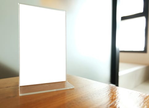 Mock up Menu frame standing on wood table in Bar restaurant cafe. space for text