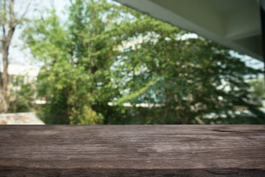 Image of wooden table in front of abstract blurred background of outdoor garden lights. can be used for display or montage your products.Mock up for display of product.