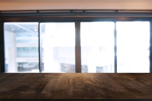 Empty wooden table in front of abstract blurred background of coffee shop . can be used for display or montage your products.Mock up for display of product